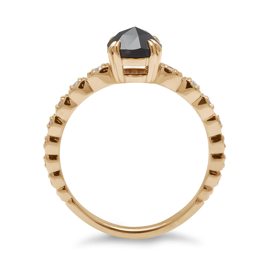 Side view of a solitaire ring with a round black diamond with white diamond pave around the band set in yellow gold.