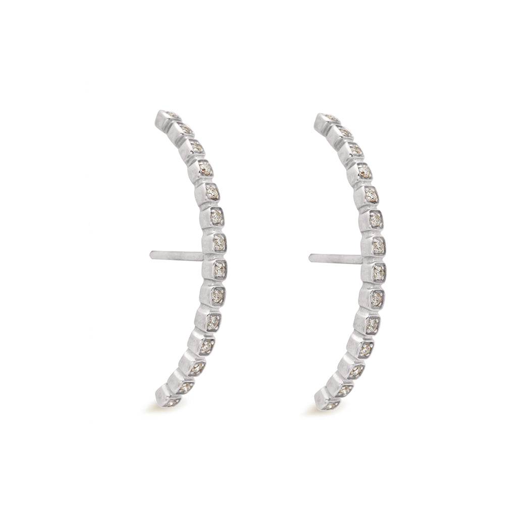 A pair of grey diamond dusted curve earrings set in white gold both earrings angled., White Gold