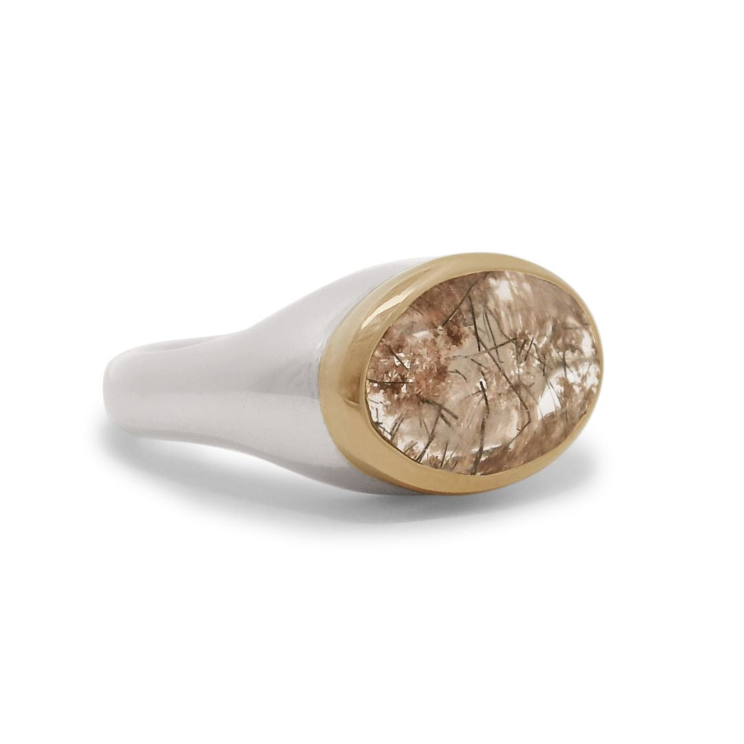 A terra firma cabochon quartz signet ring bezel set in a 14k yellow gold bezel and sterling silver shank. 