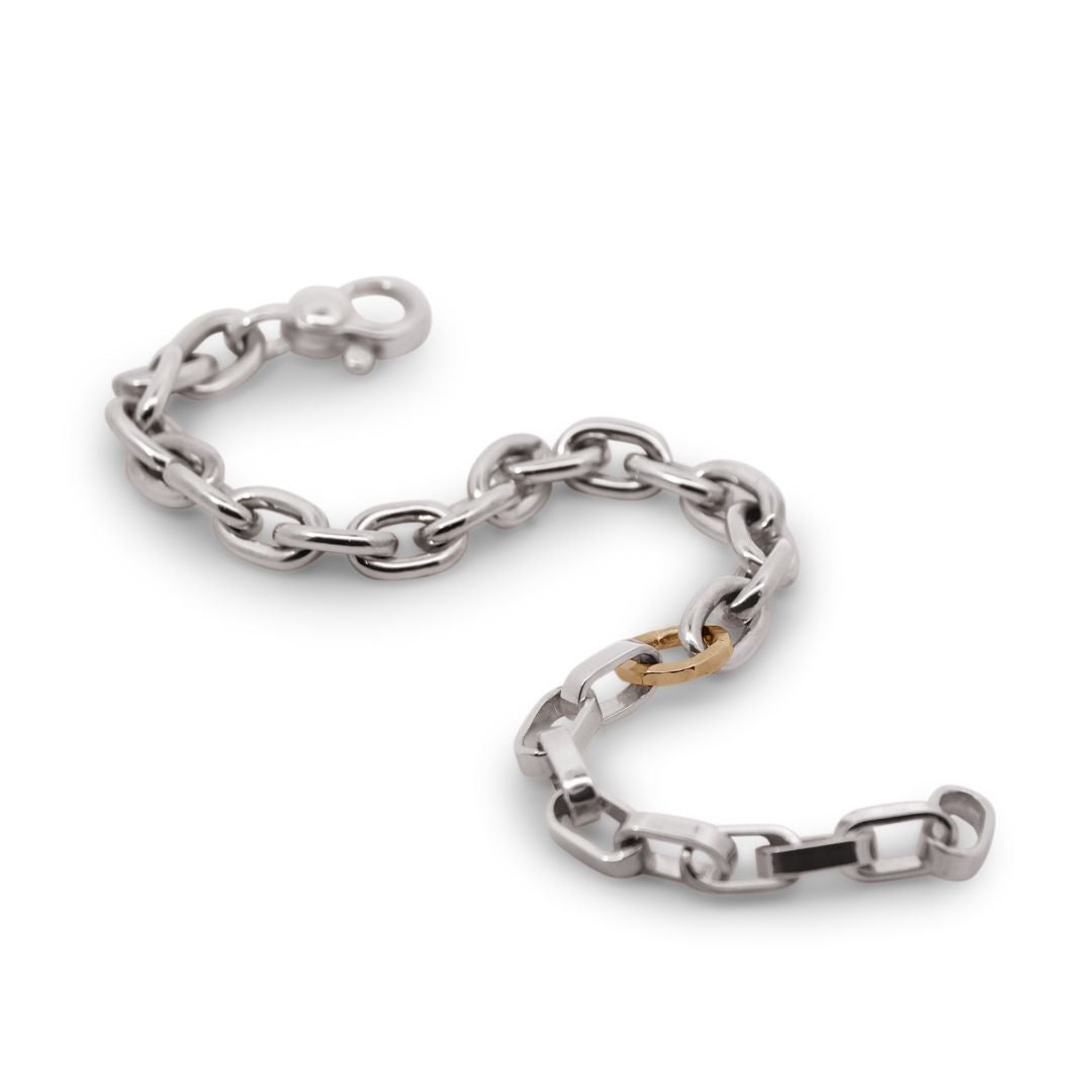Silver chain bracelet with a gold clasp on a white background
