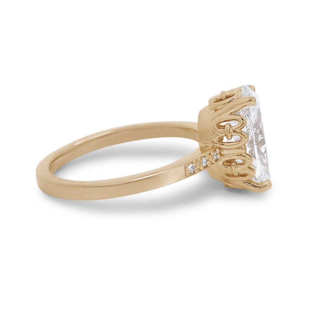 A side profile of a 2.11 ct white oval lab diamond engagement ring featuring pave diamonds on the band set in 14kt yellow gold.