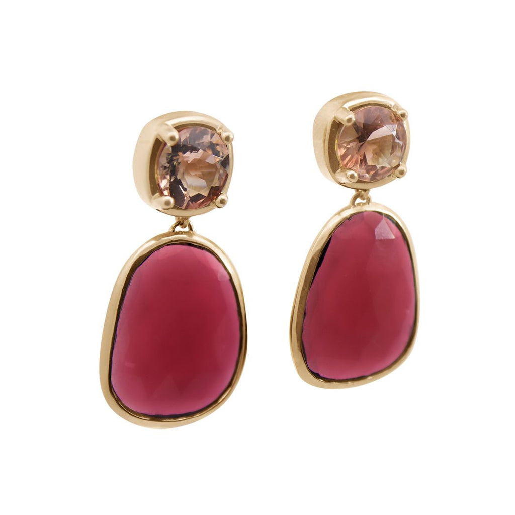 A pair of drop earrings featuring a cushion cut sunstone and a pink tourmaline slice set in yellow gold on a white background