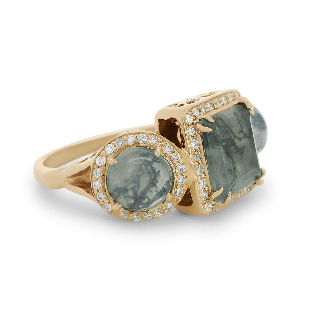 3/4 angle of a moss agate ring encircled with white diamond pavé set in 14kt yellow gold. 