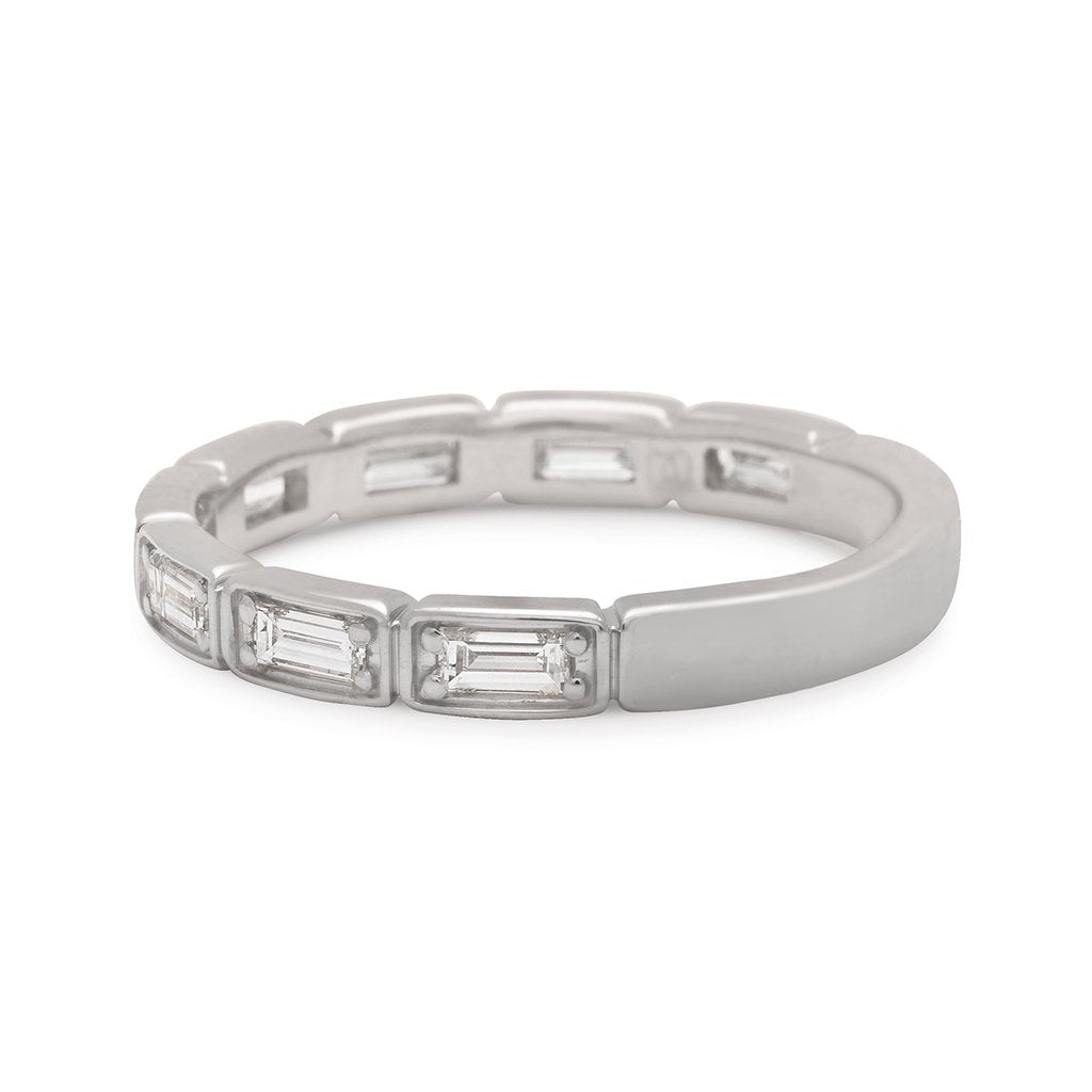 Angled view of a white diamond baguette band that has diamond goes around 3/4 of the band set in white gold.