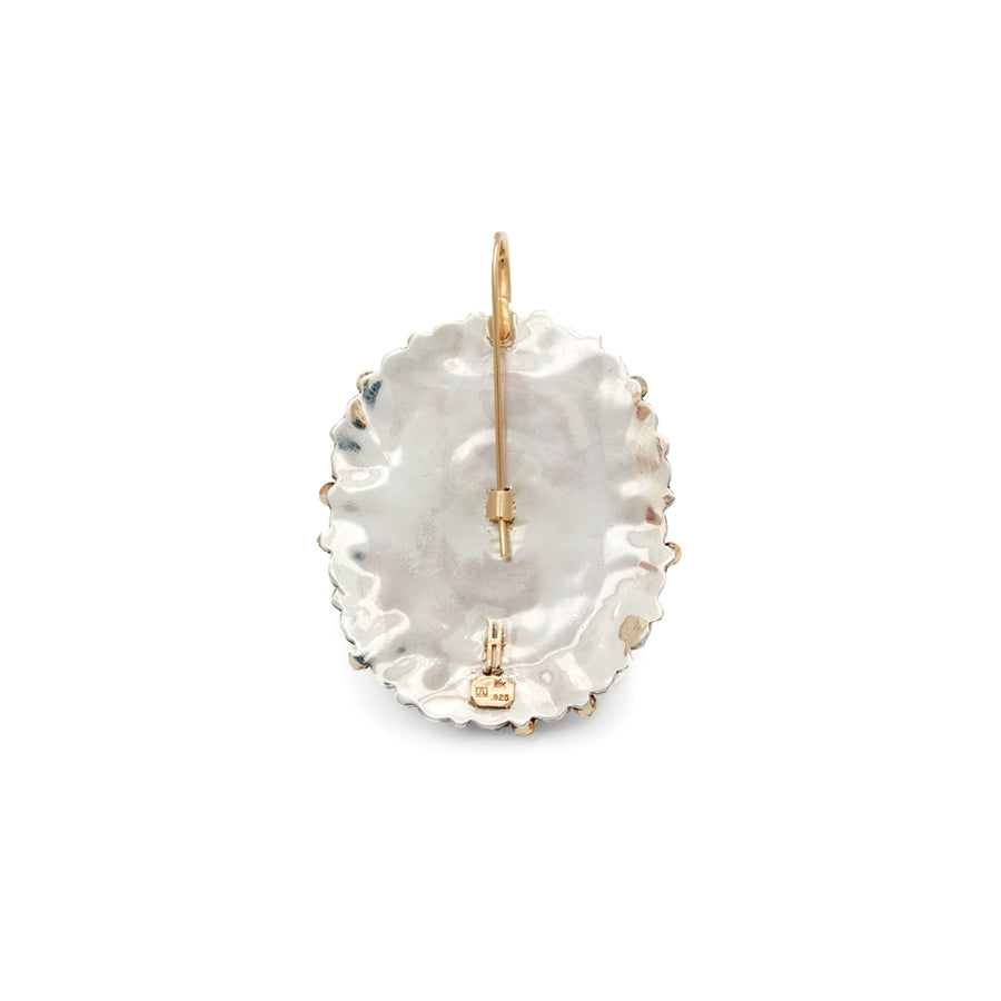 A single oval cabochon hoop with turquoise stones and a white diamond pave on the hook of the earring a back facing view.