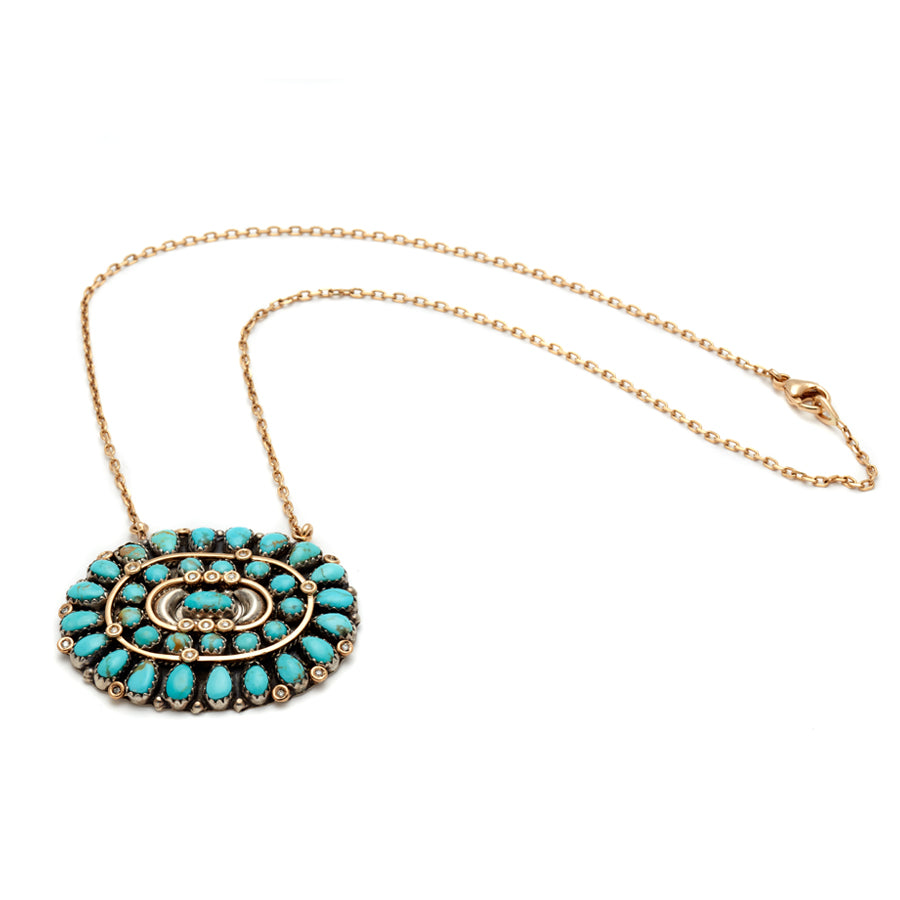 Full view of an oval cabochon charm with turquoise stones on a 16" chain in yellow gold.