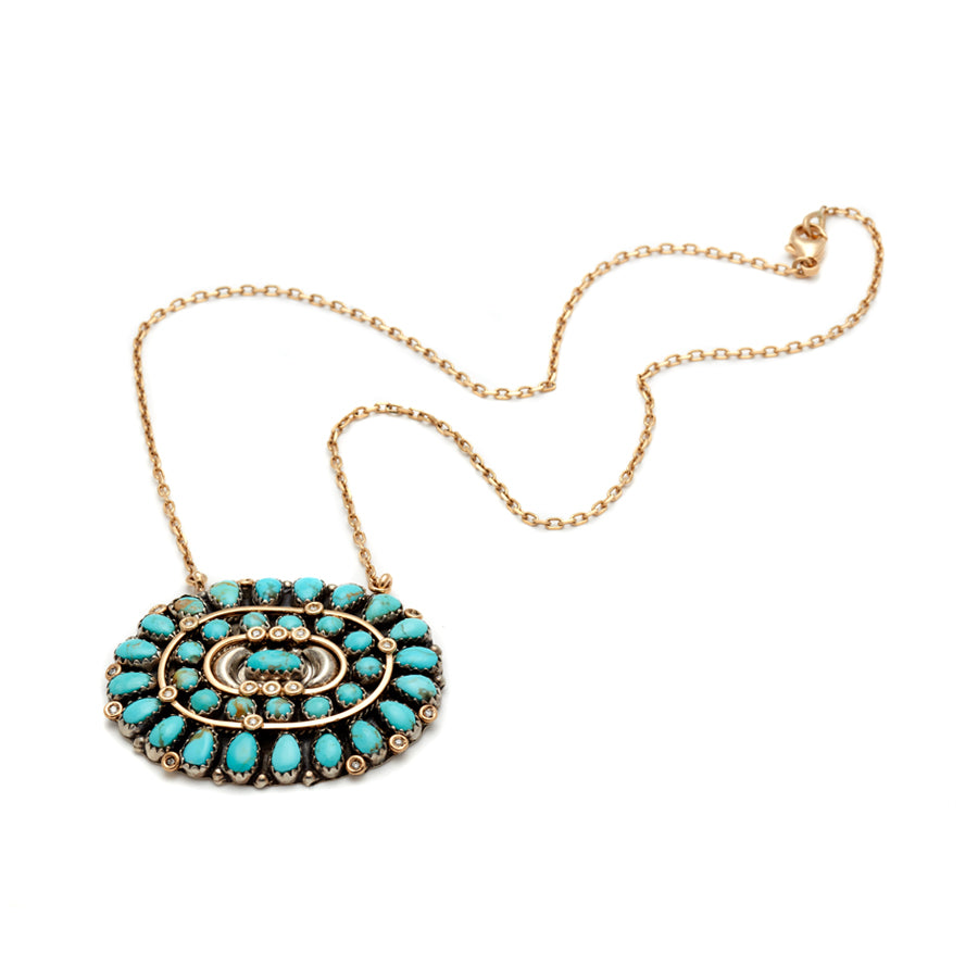 Full view of an oval cabochon charm with turquoise stones on a 16" chain in yellow gold.