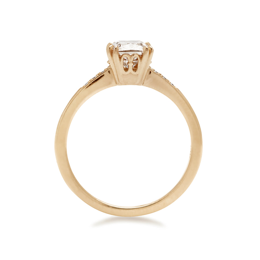 Side view of a solitaire ring with a cushion cut 1.00ct champagne diamond with white diamond pave on either side set in yellow gold.