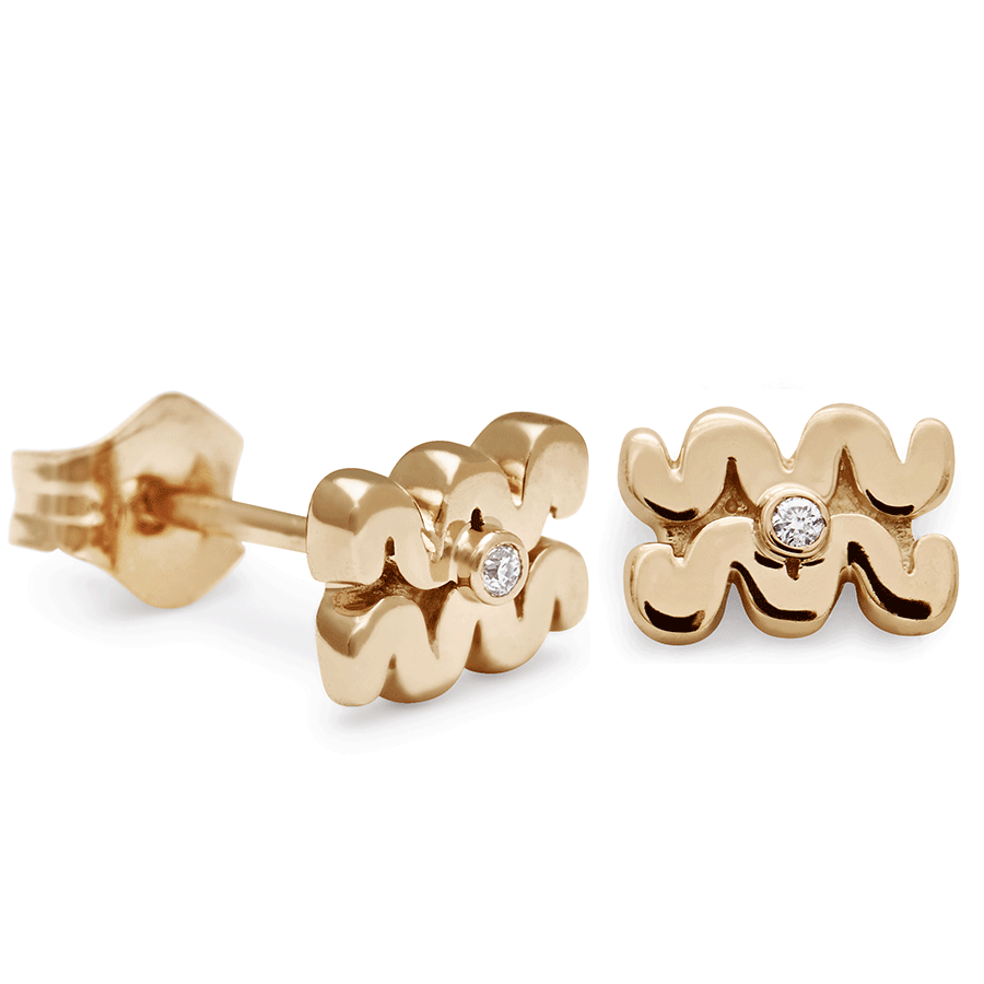 A pair of Aquarius stud earrings set in yellow gold with a white diamond accent stone with one earring angled.