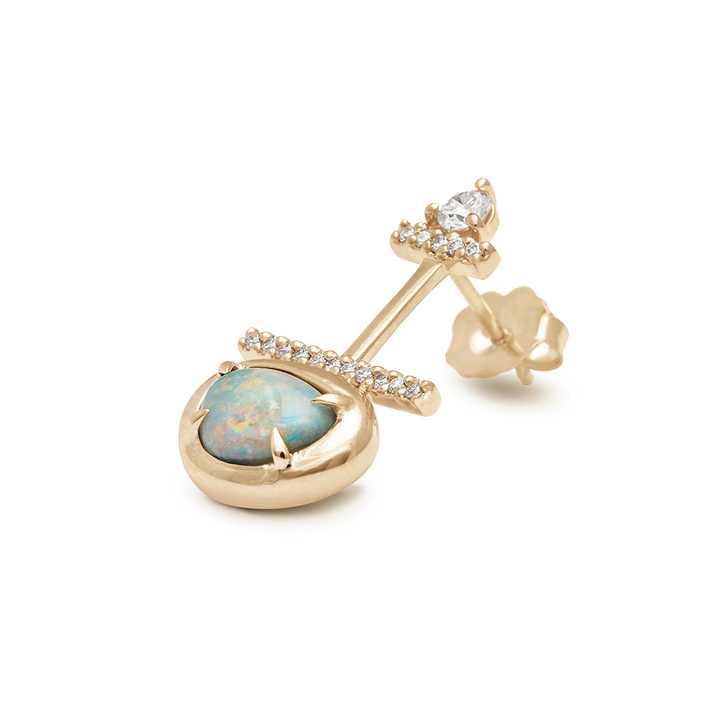 Angled view of a single drop earring with a round white diamond at the top and then two lines of white diamond pave and a one of a kind opal at the bottom set in bezel with claw prongs set in yellow gold.
