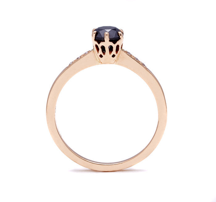 Side view of a solitaire ring with a round 0.50ct black diamond with white diamond pave on either side set in rose gold., Rose Gold