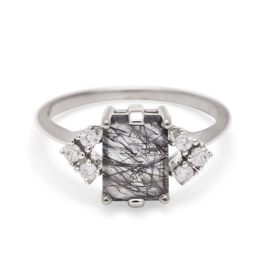 A ring with an emerald cut black rutilated quartz center with three round white diamonds on either side in arrow shape, set in white gold., White Gold