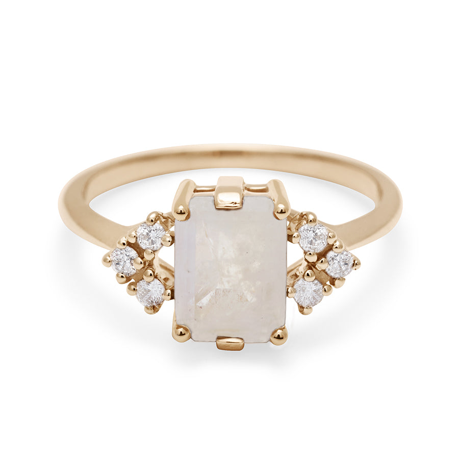 A ring with an emerald cut rainbow moonstone center with three round white diamonds on either side in arrow shape, set in yellow gold., Yellow Gold
