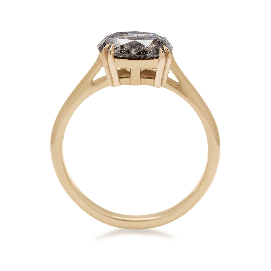 A side view of an east/west solitaire ring with an oval grey diamond stone set in yellow gold.