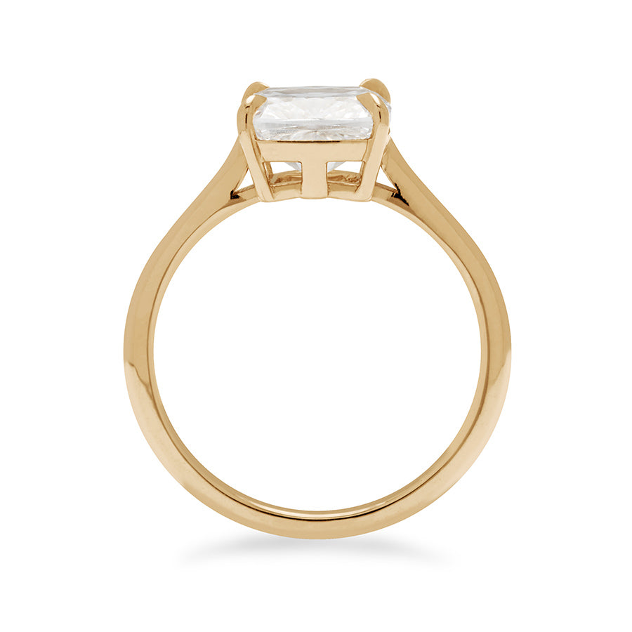 Side view of an east/west solitaire ring with a cushion cut white diamond stone set in yellow gold.