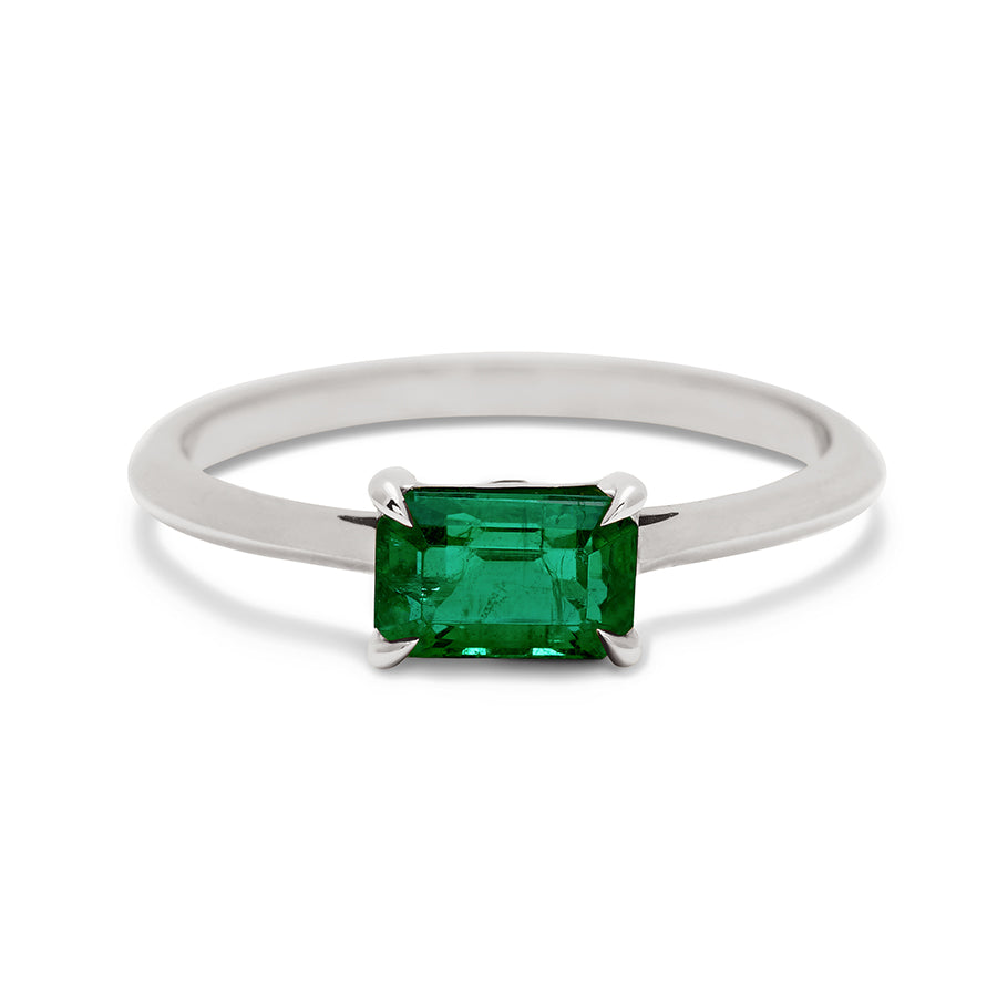 An east/west solitaire ring with an emerald shape green emerald stone set in white gold., White Gold