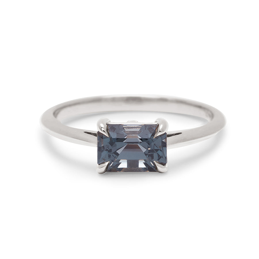 An east/west solitaire ring with an emerald shape grey spinel stone set in white gold., White Gold