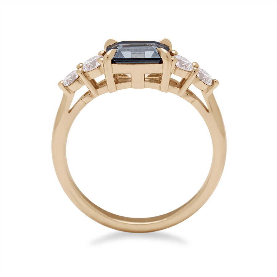 Side view of a ring with a grey spinel center stone with two white diamonds on either side set in recycled yellow gold., Yellow Gold