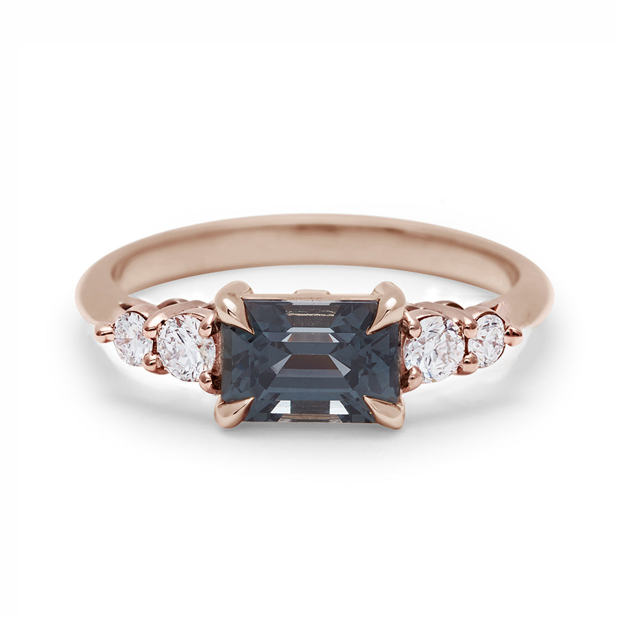 A ring with a grey spinel center stone with two white diamonds on either side set in recycled rose gold., Rose Gold
