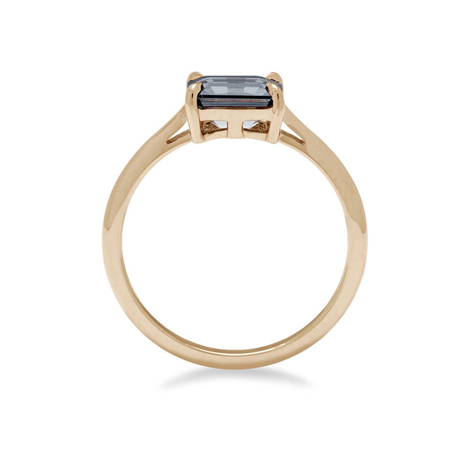 Side view of an east/west solitaire ring with an emerald shape grey spinel stone set in yellow gold., Yellow Gold