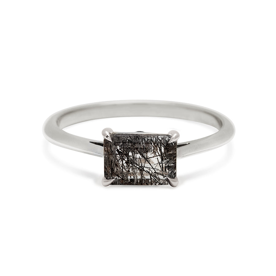 An east/west solitaire ring with an emerald shape black rutilated quartz stone set in white gold., White Gold