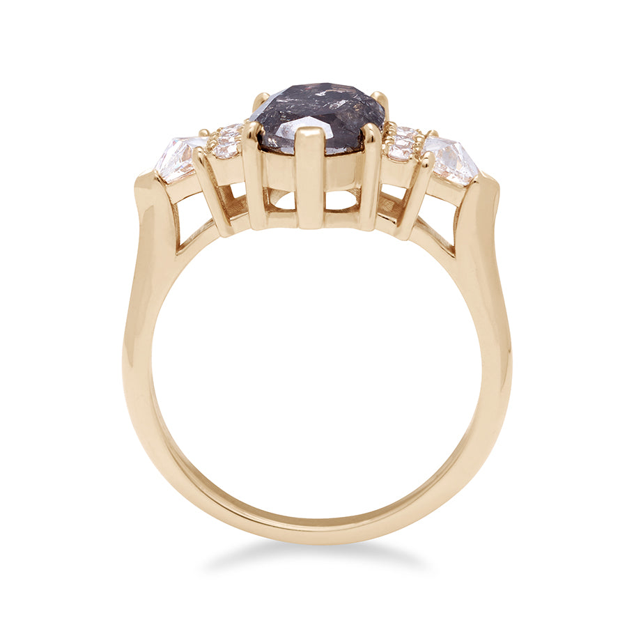 Side view of an oval shape 1.38ct grey diamond center stone ring with three round white diamonds on either and two white diamond trillions on the outer edges of each side set in yellow gold.