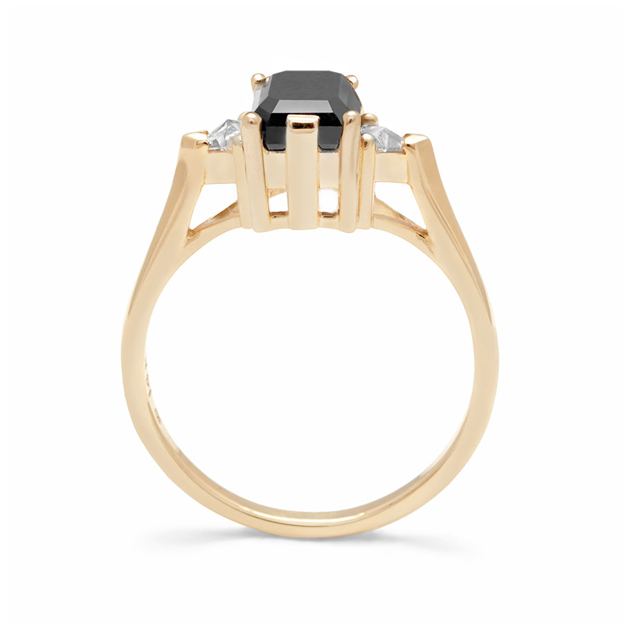Side view of a three stone engagement ring with an emerald cut and emerald shape 7x5mm black diamond center stone with two white diamond trillion side stones set in yellow gold., Yellow Gold