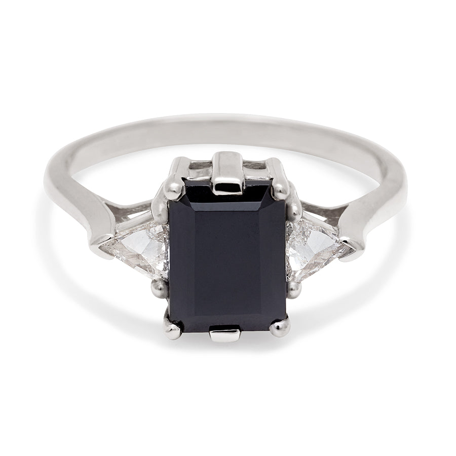 A three stone engagement ring with an emerald cut and emerald shape 8x6mm black diamond center stone with two white diamond trillion side stones set in white gold., White Gold