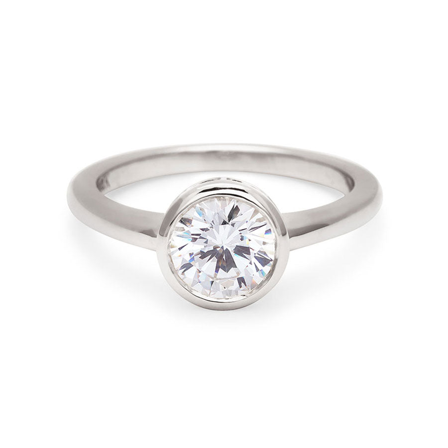 A round brilliant cut bezel set white diamond set in white gold., White Gold