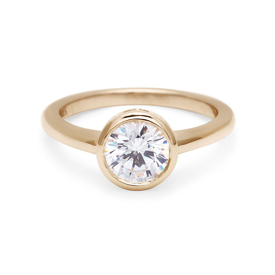 A round brilliant cut bezel set white diamond set in yellow gold., Yellow Gold