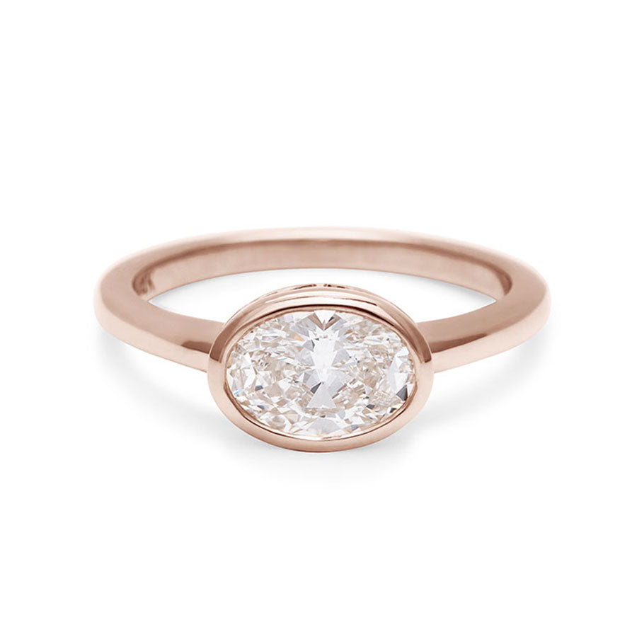 A east west oval shaped brilliant cut bezel set white diamond set in rose gold., Rose Gold