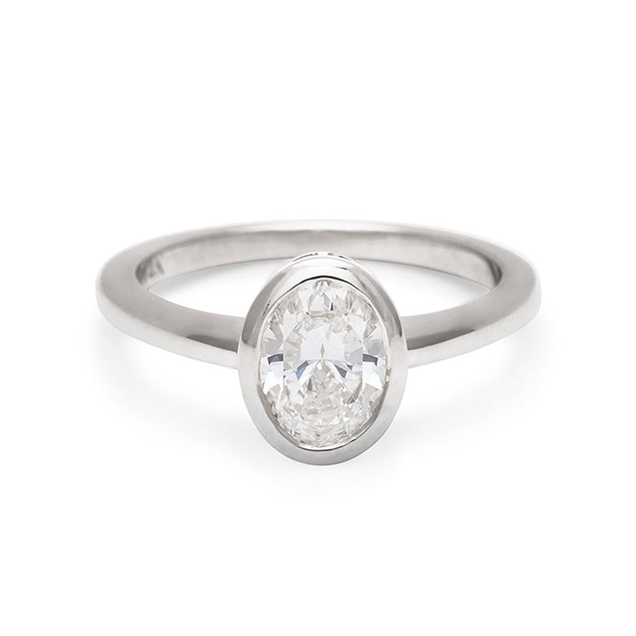 An oval brilliant cut bezel set lab white diamond set in white gold., White Gold