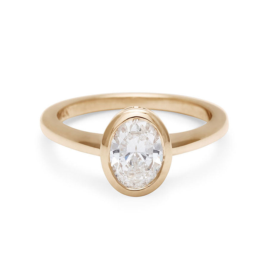 An oval brilliant cut bezel set lab white diamond set in yellow gold., Yellow Gold