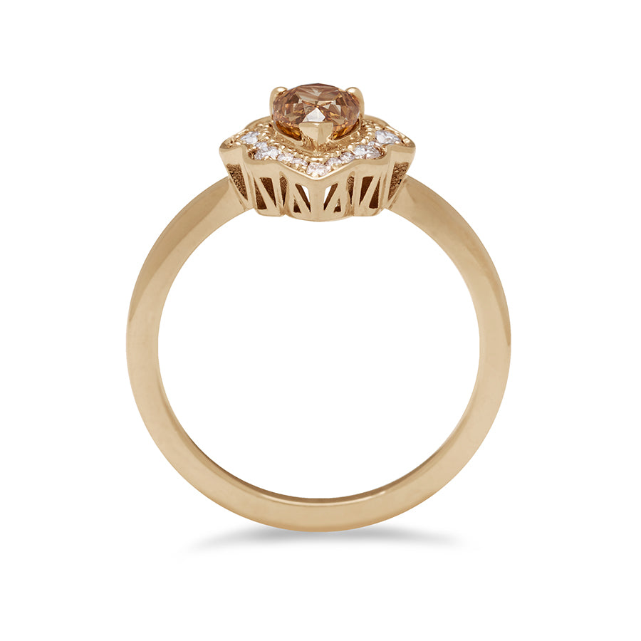 Side view of a pear shaped champagne diamond ring set in a halo of white diamonds and in yellow gold.