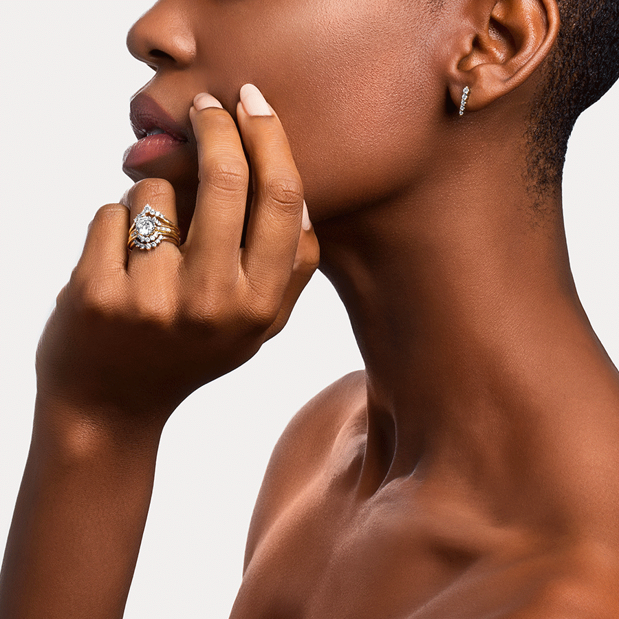 A band with white diamonds in ascending size set in yellow gold above a solitaire white diamond engagement ring and two diamond dusted curve bands. Available in Yellow Gold, Rose Gold, White Gold.