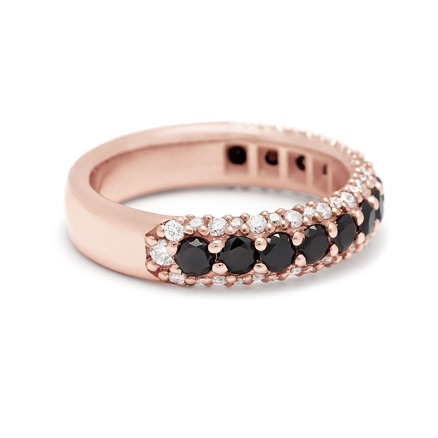 Angled view of a band with round black diamonds in a 3/4 pave around a rose gold band with white diamond accents on both top and bottom.