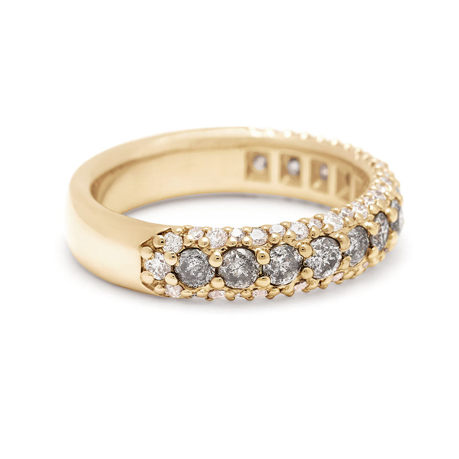 Angled view of a band with round grey diamonds in a 3/4 pave around a yellow gold band with white diamond accents on both top and bottom.
