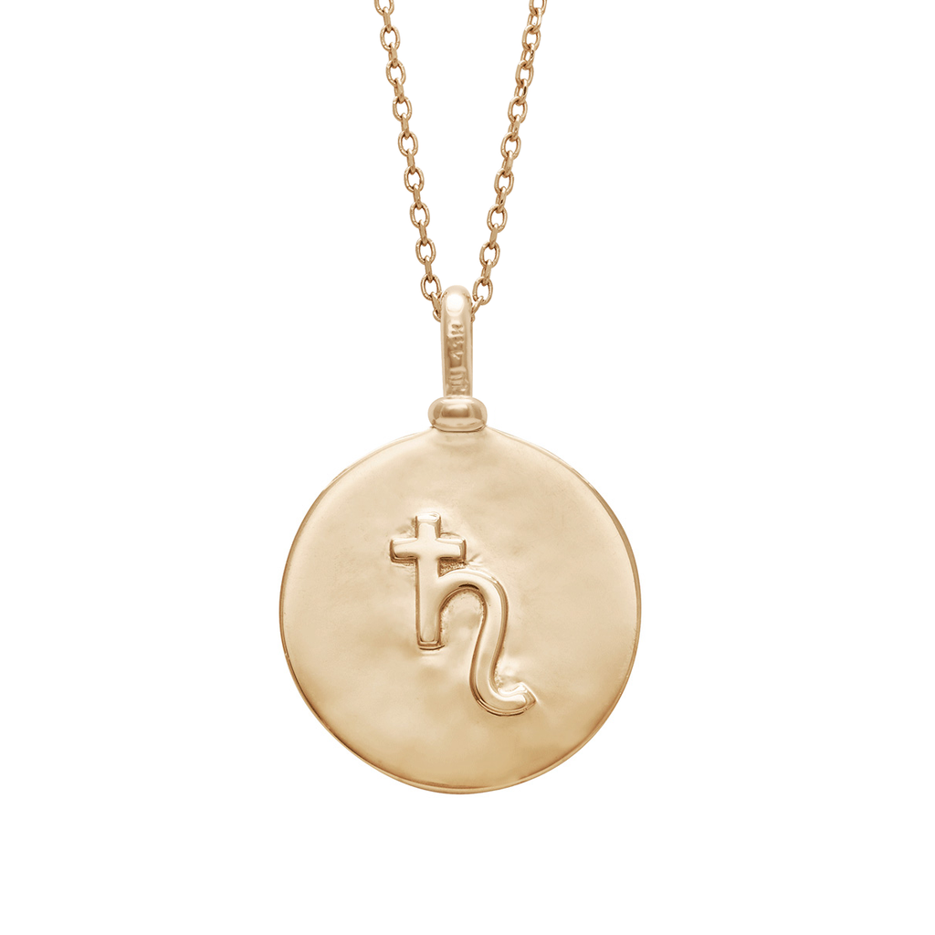 A 18mm charm with the saturn sign set in yellow gold on a yellow gold chain.