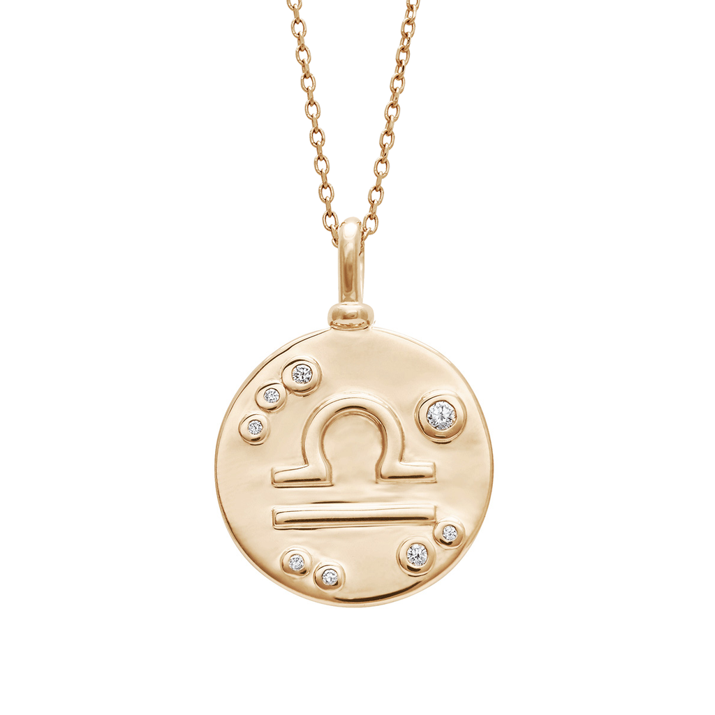 A 18mm charm with the Libra zodiac sign set in yellow gold with white diamond stones on a yellow gold chain.