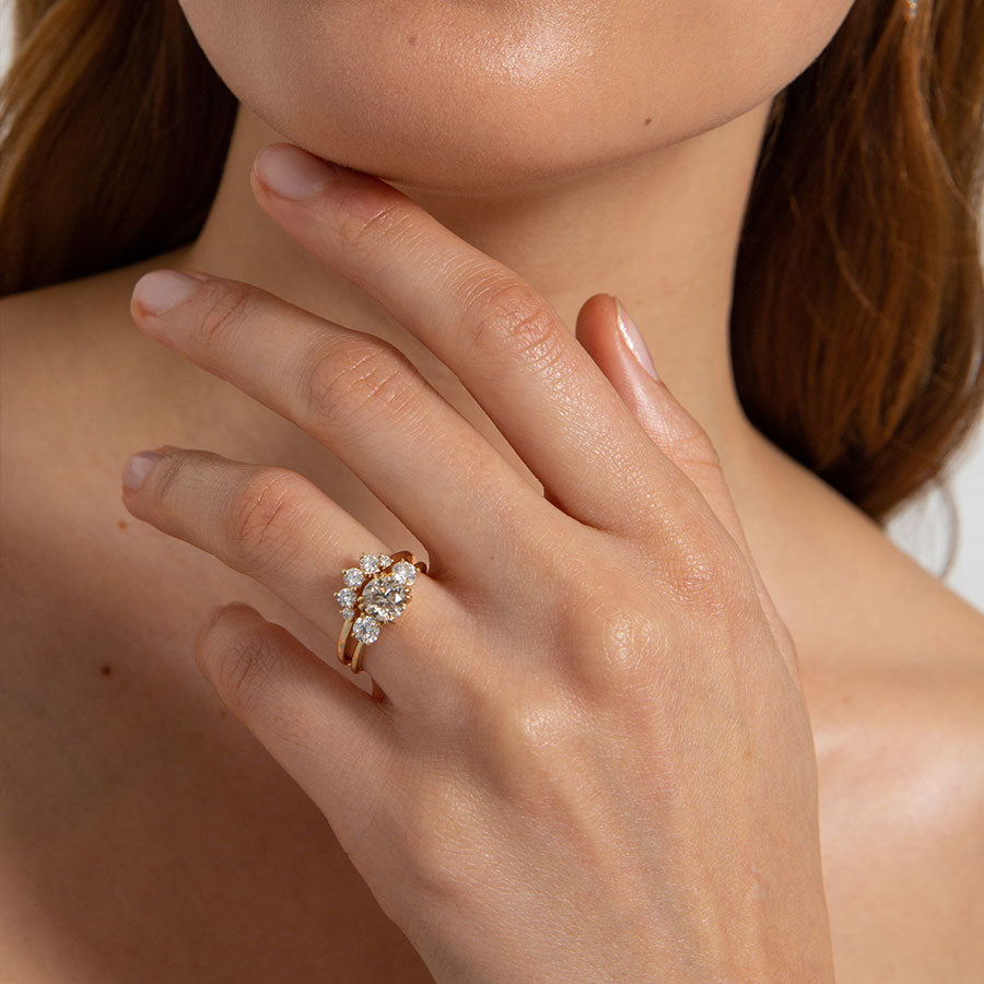 Angled view of a curved 5 grey diamond band set in yellow gold.
