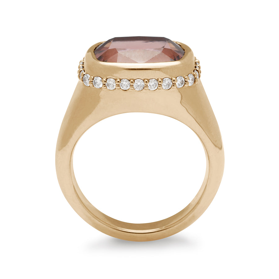 Side view of a cushion cut zircon stone set in a signet style with a white diamond pave halo set in yellow gold.