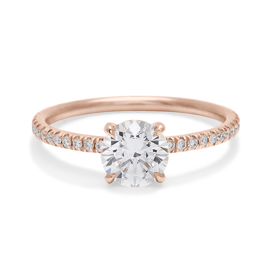 A solitaire round white diamond ring with double claw prongs with white diamond pave on the band set in rose gold., Rose Gold