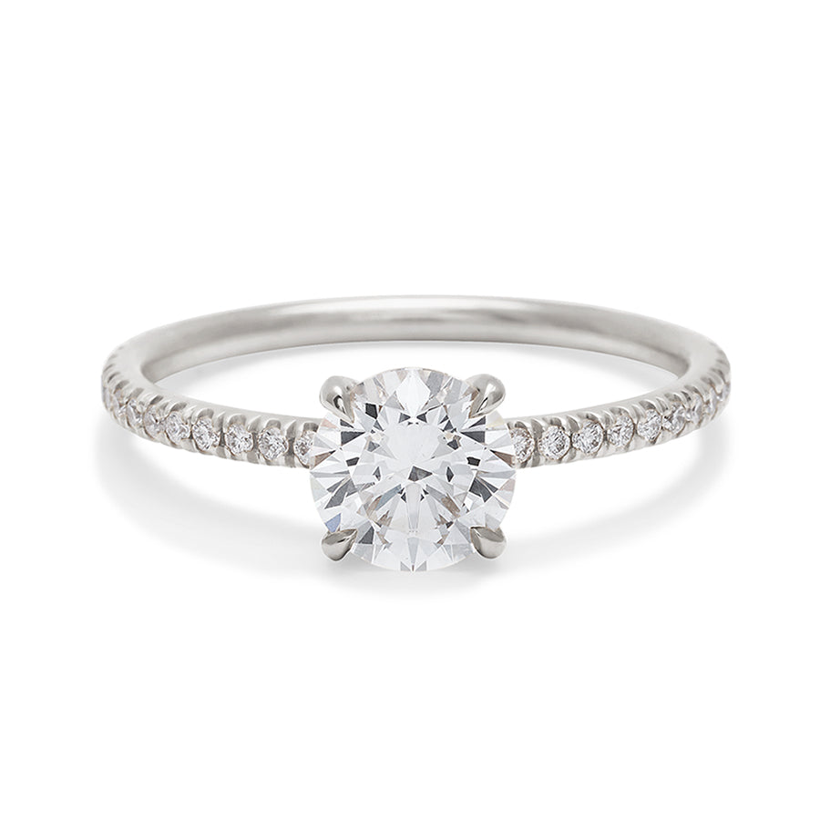 A solitaire round white diamond ring with double claw prongs with white diamond pave on the band set in white gold., White Gold