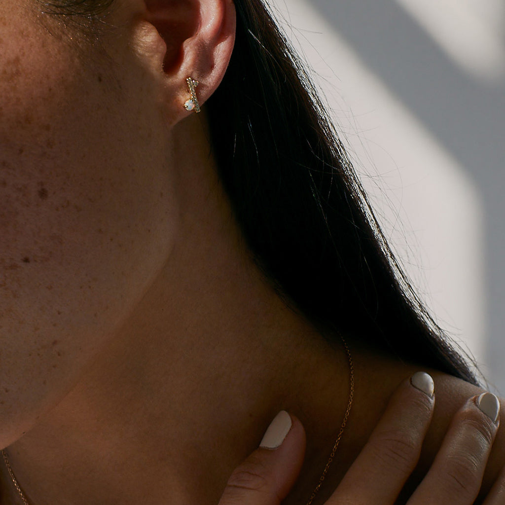A single straight line of white diamond pave with an opal accent stones on one side earring set in yellow gold on a medium-complexion model's earring., White Gold, Rose Gold, Yellow Gold