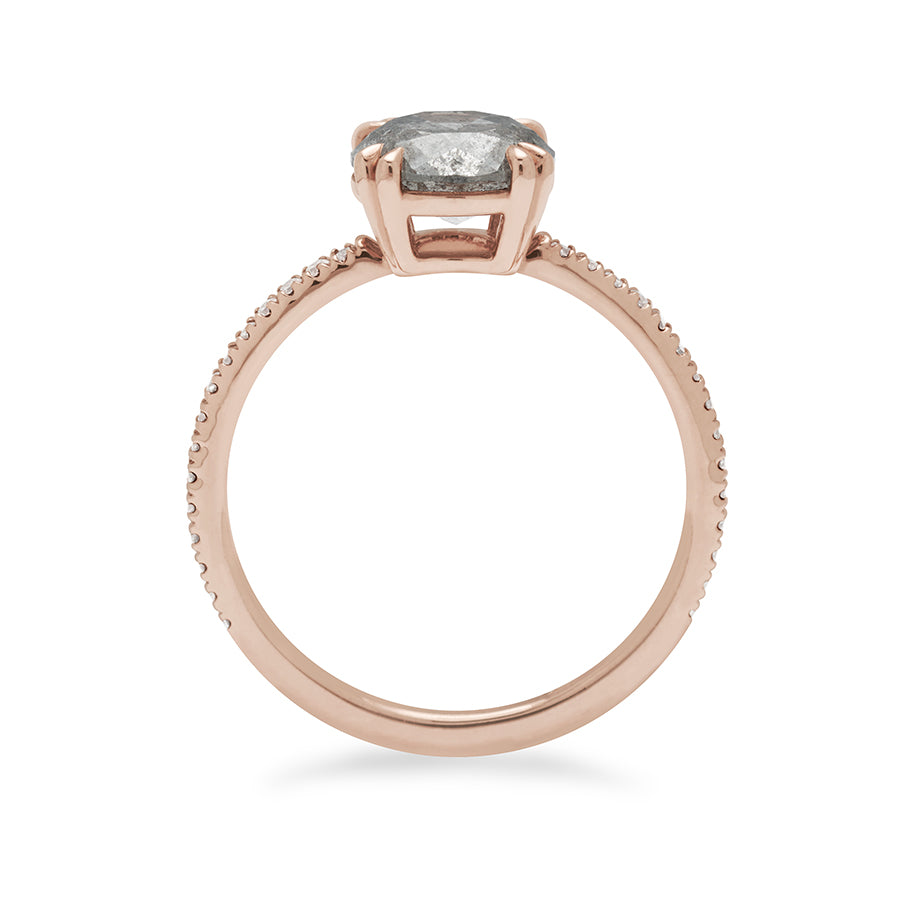 Side view of a solitaire round grey diamond ring with double claw prongs with white diamond pave on the band set in rose gold.