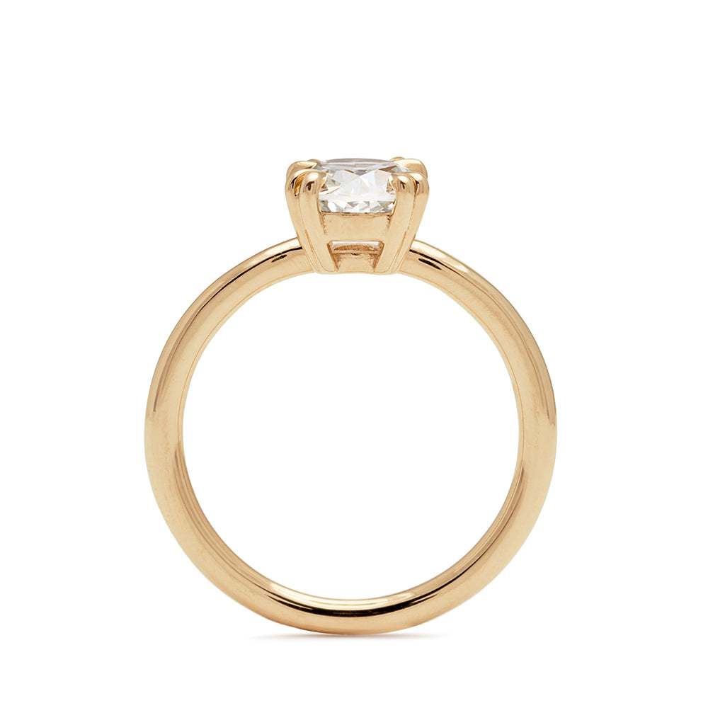 Side view of a solitaire 1.20ct round white diamond ring with double claw prongs set in yellow gold.