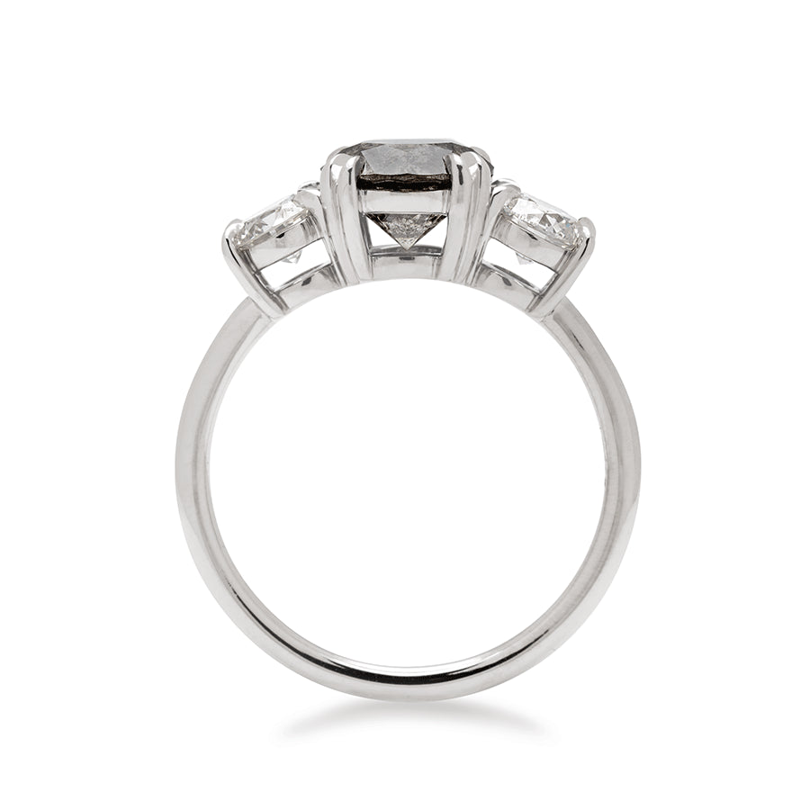 Side view of a three stone engagement ring with a round shape grey diamond center stone with two white diamond round side stones set in white gold., White Gold
