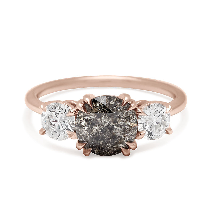 A three stone engagement ring with a round shape grey diamond center stone with two white diamond round side stones set in rose gold., Rose Gold