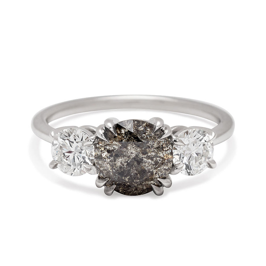 A three stone engagement ring with a round shape grey diamond center stone with two white diamond round side stones set in white gold., White Gold
