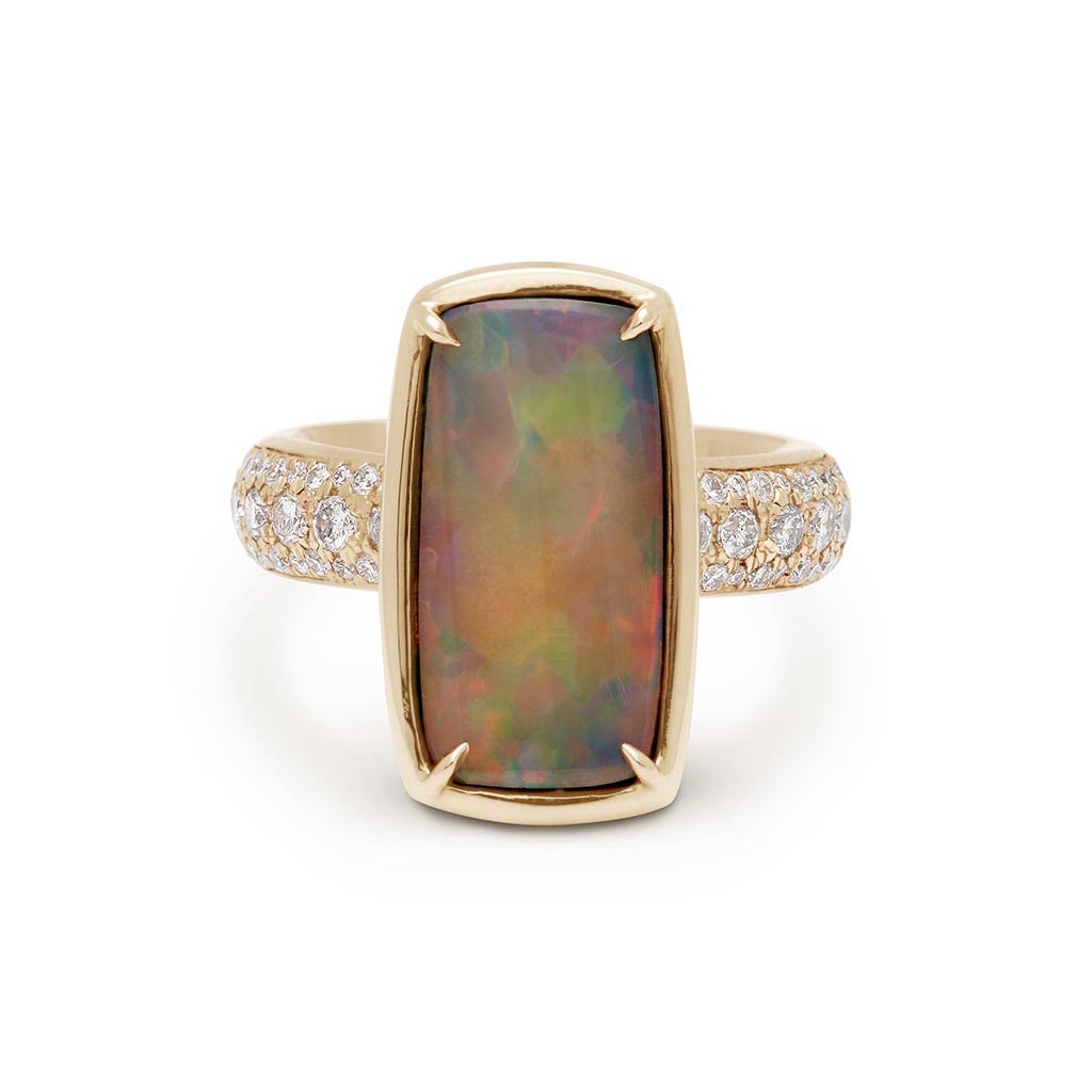 A ring with an emerald shaped black opal set in claw prongs and bezel set yellow gold with a white diamond 3/4 pave band.